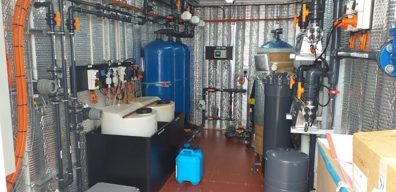 Containerised water treatment skid with filtration and dosing tanks